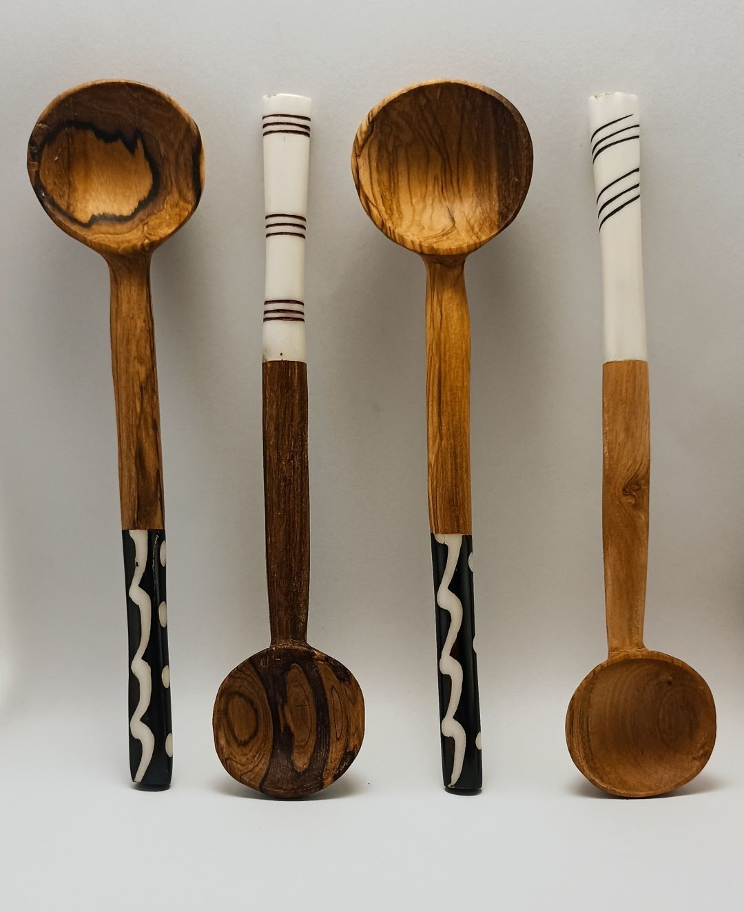 A collection of wooden spoons with pattern bone inserts